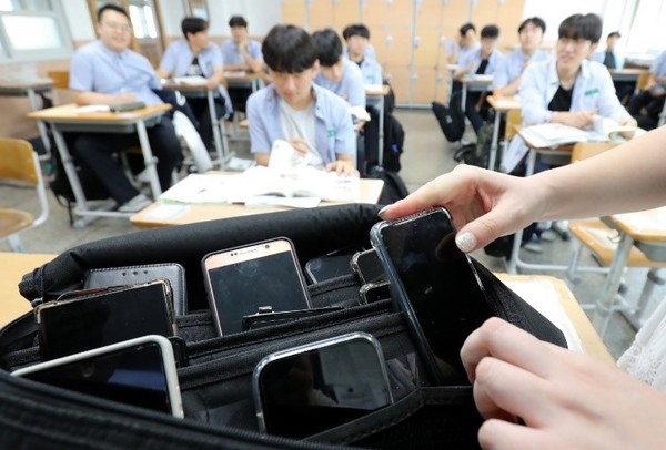 教育部为了确立教权及保护学生的学习权,开始在教育现场实施《教师学生生活指导通知》等,在课堂上使用手机的话可以没收。图为去年9月,在大田中区东山高一教室里让学生上交手机。该校通过与学生会、家长协商,在上学时没收学生的手机,并在放学时返还。【照片来源:NEWS1】