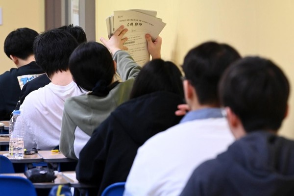 图为韩国考生领取模拟考试试卷。【照片来源 : 韩联社】