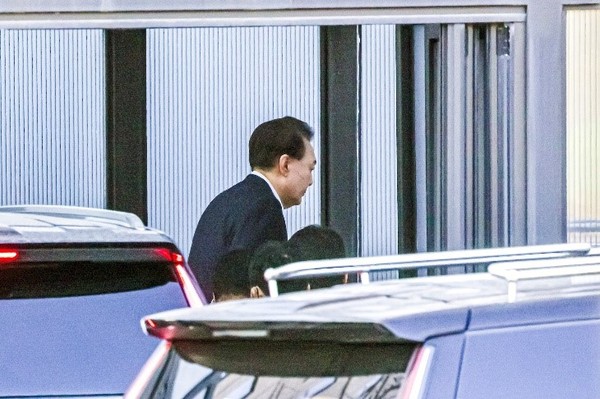15日,因涉嫌“12•3内乱事件”而被捕的尹锡悦总统抵达京畿果川高级公职者犯罪调查处(公调处)办公楼正门后避开摄影区,从后门进入大楼。【照片来源:果川=金成龙 记者】